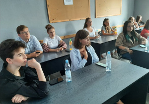 Grupa młodzieży słucha wykładu