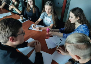 Grupa młodzieży pracuje przy stole