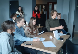 Grupa młodzieży słucha prezentacji